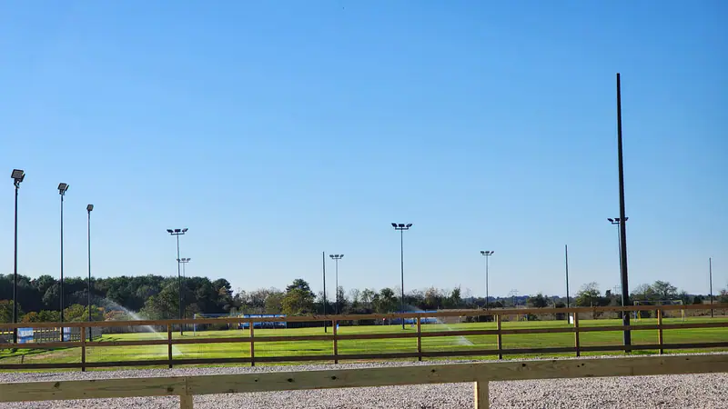 Natural grass training fields under a clear sky