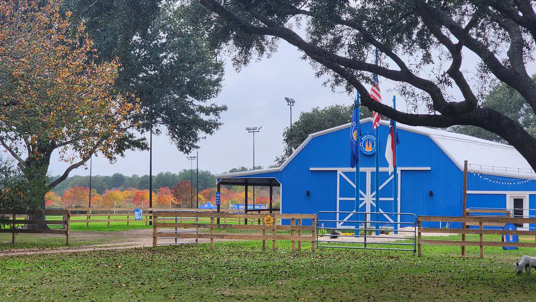 The blue clubhouse barn under oak trees at the Barcelona Center of Excellence