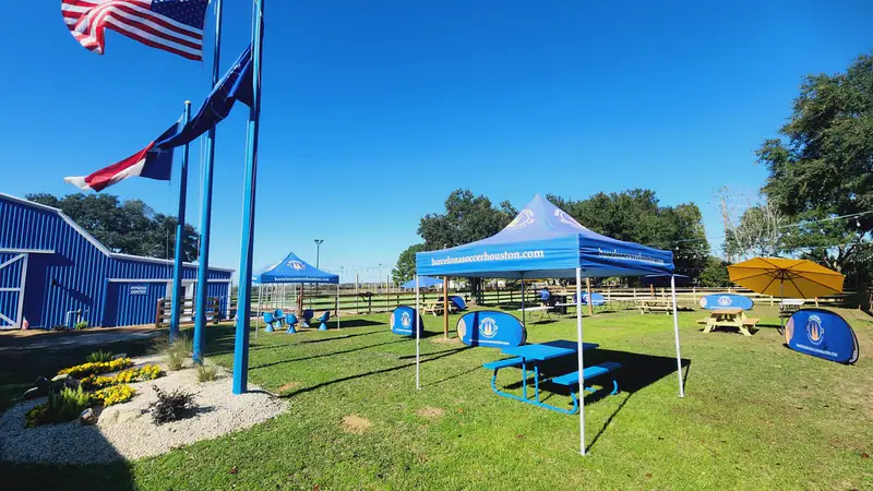 Flags and shaded seating beside the fields