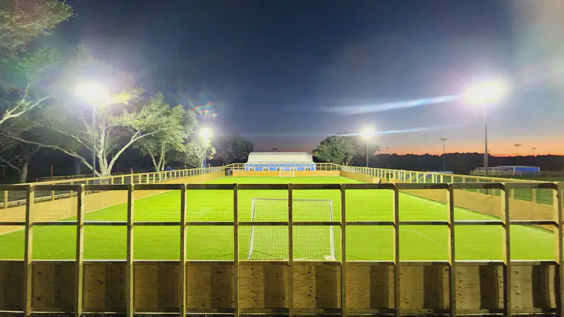 The 7v7 artificial turf field under floodlights at night