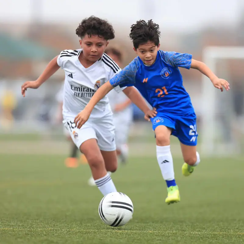 Two youth players competing for the ball